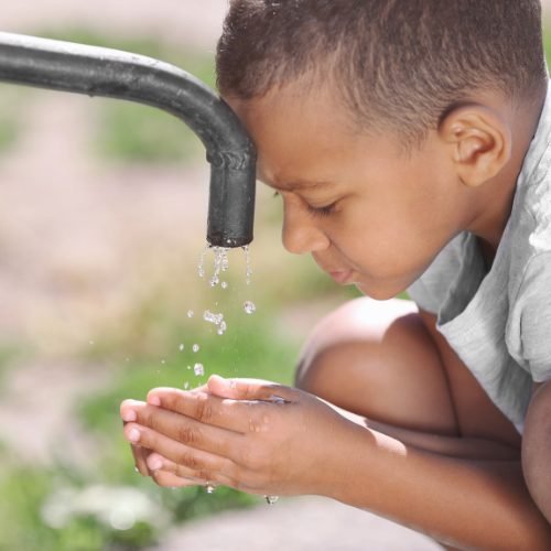 Enfant buvant l’eau d’un robinet